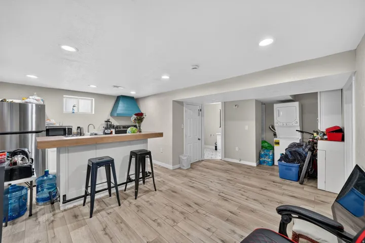 Open-concept living space featuring wood-finish flooring, recessed lighting, and a kitchen area with a wood-finish countertop island