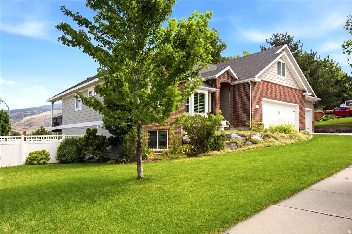 Brick and siding exterior featuring an attached three-plus-car garage
