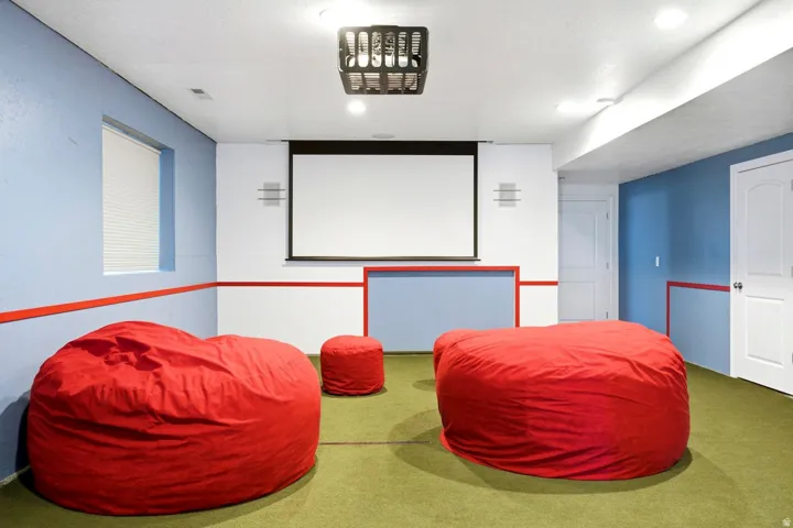 Projector screen, recessed lighting, ceiling-mounted projector, wall-mounted speakers, paneled interior doors