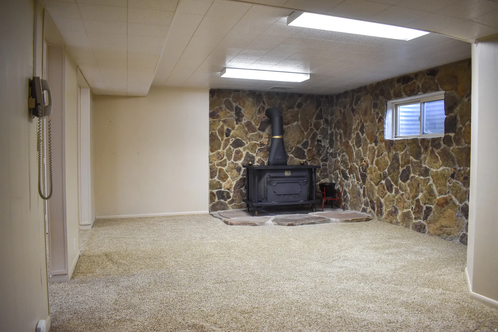 Recessed wood-burning stove with a stone surround