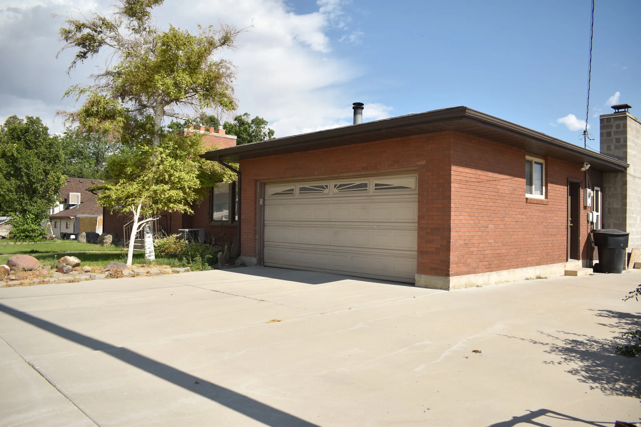 Brick exterior featuring an attached garage with a sectional door