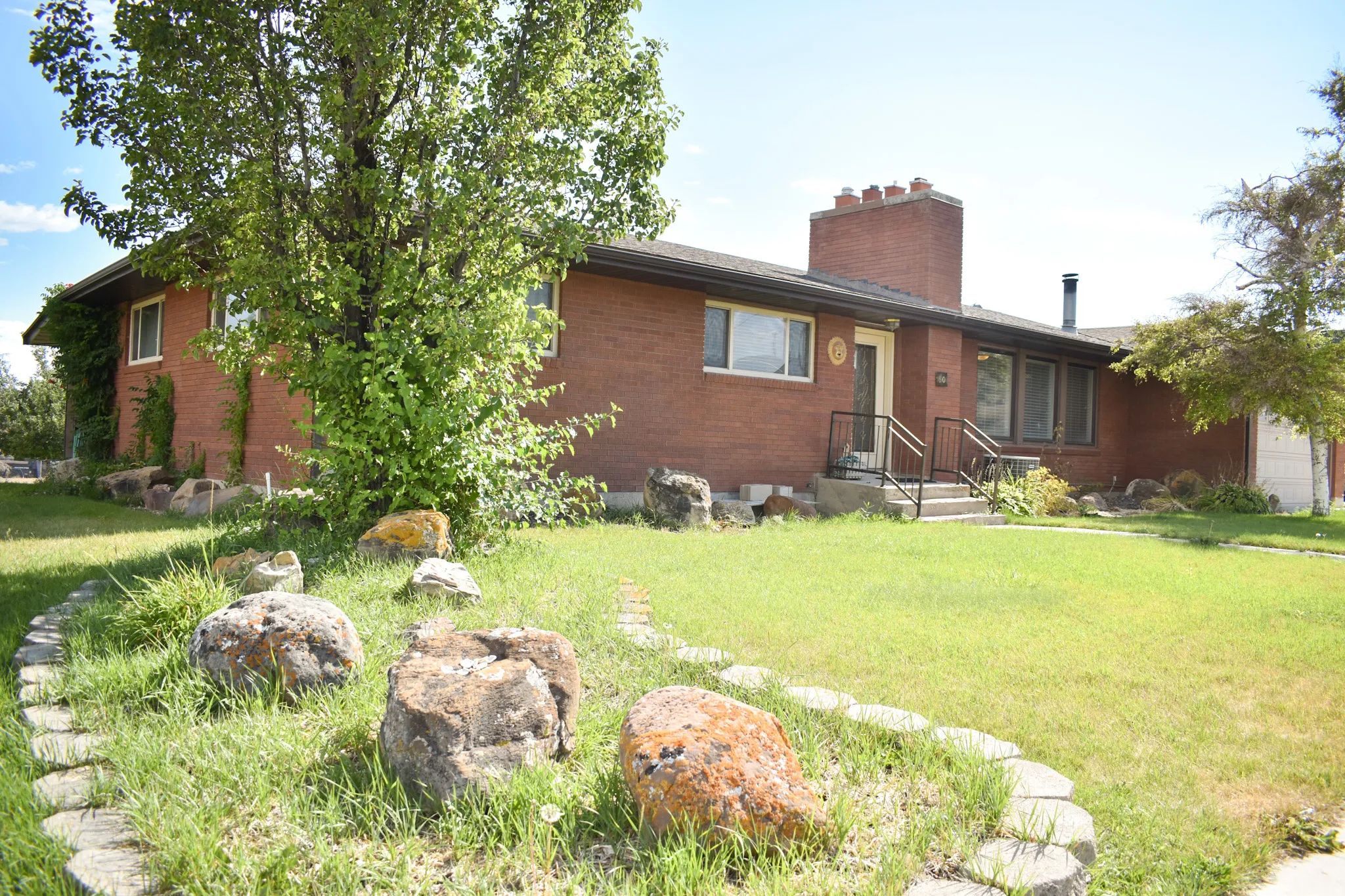 Brick exterior featuring white window frames and a prominent brick chimney