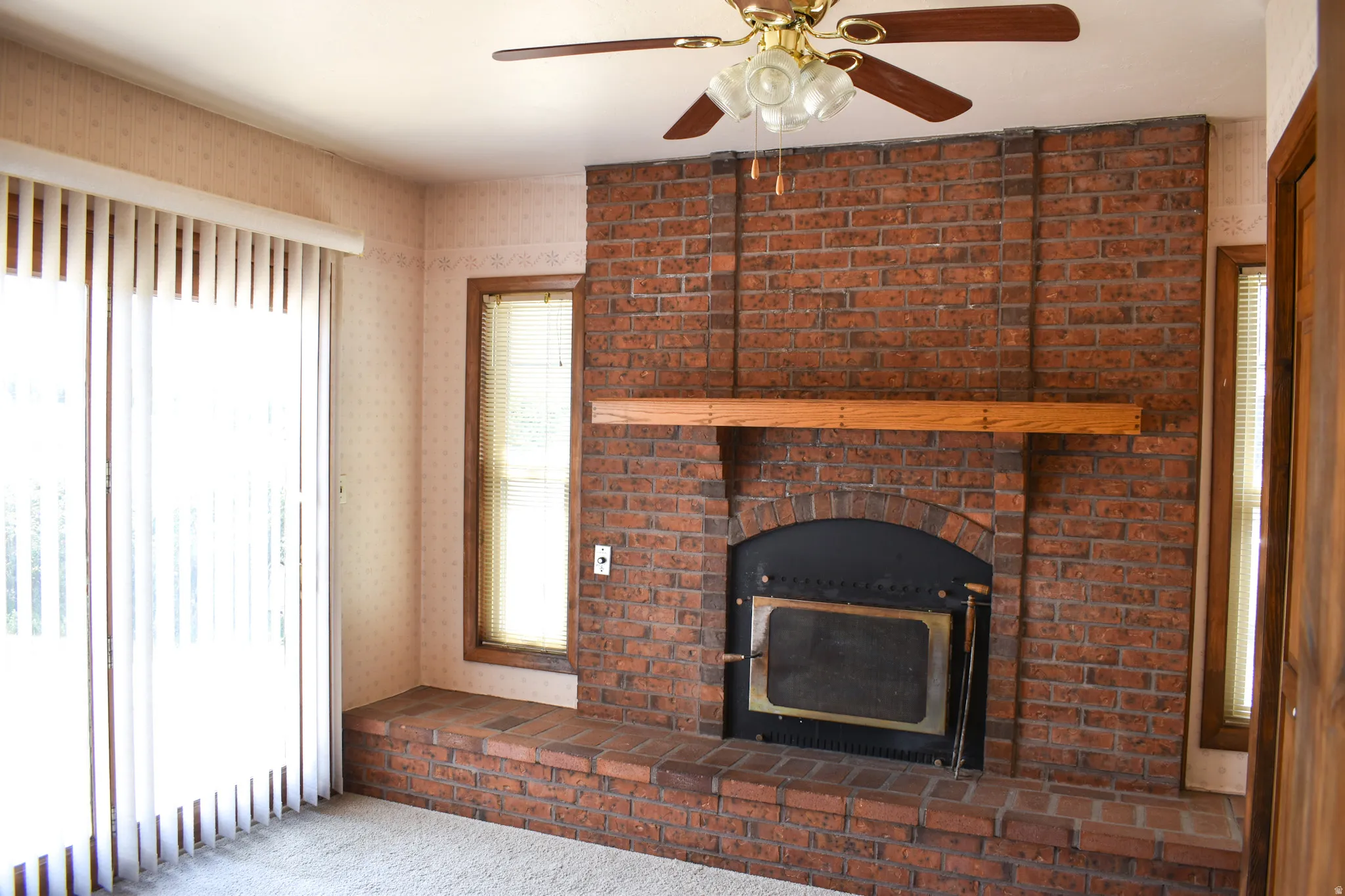 Brick fireplace with a wood mantelpiece and a raised brick hearth