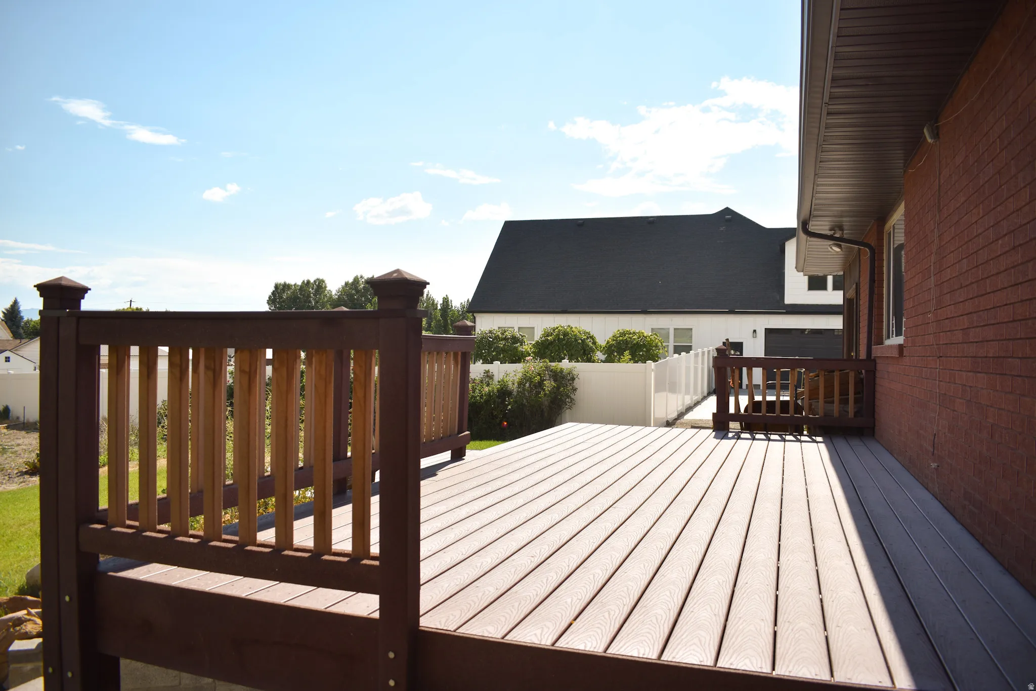 Expansive exterior deck featuring composite decking and a two-tone railing system