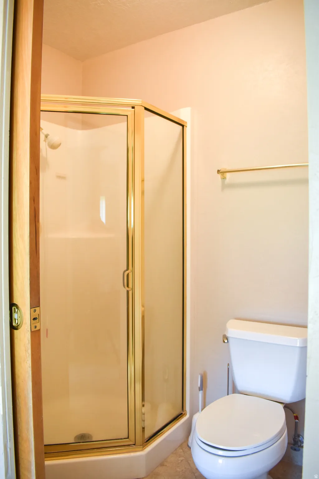 Corner shower enclosure with brass-finish framing and clear glass panels