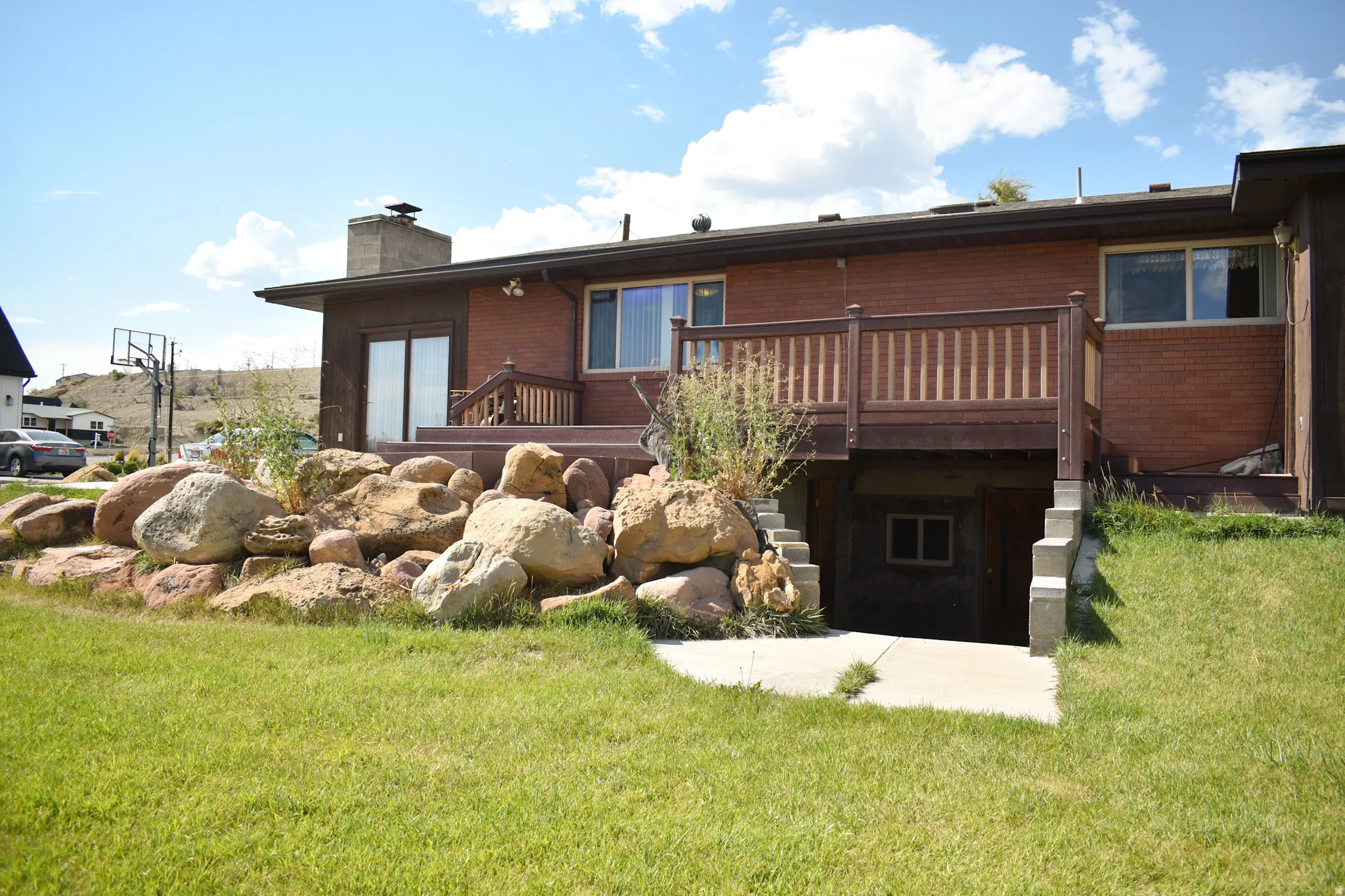 Rear exterior with a brick facade and a multi-level wood-finish deck