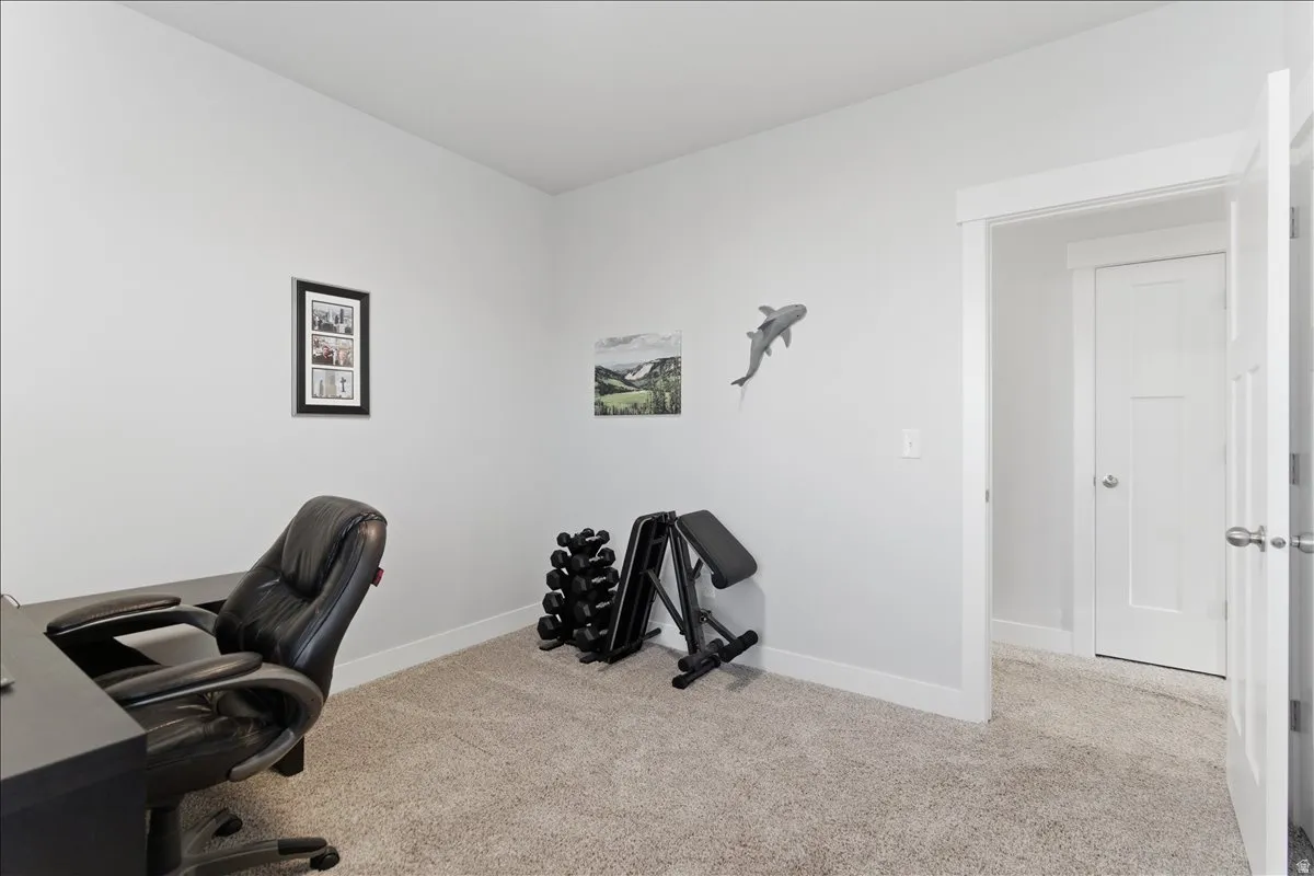 Neutral-toned room with light gray walls, carpeted flooring, and white trim