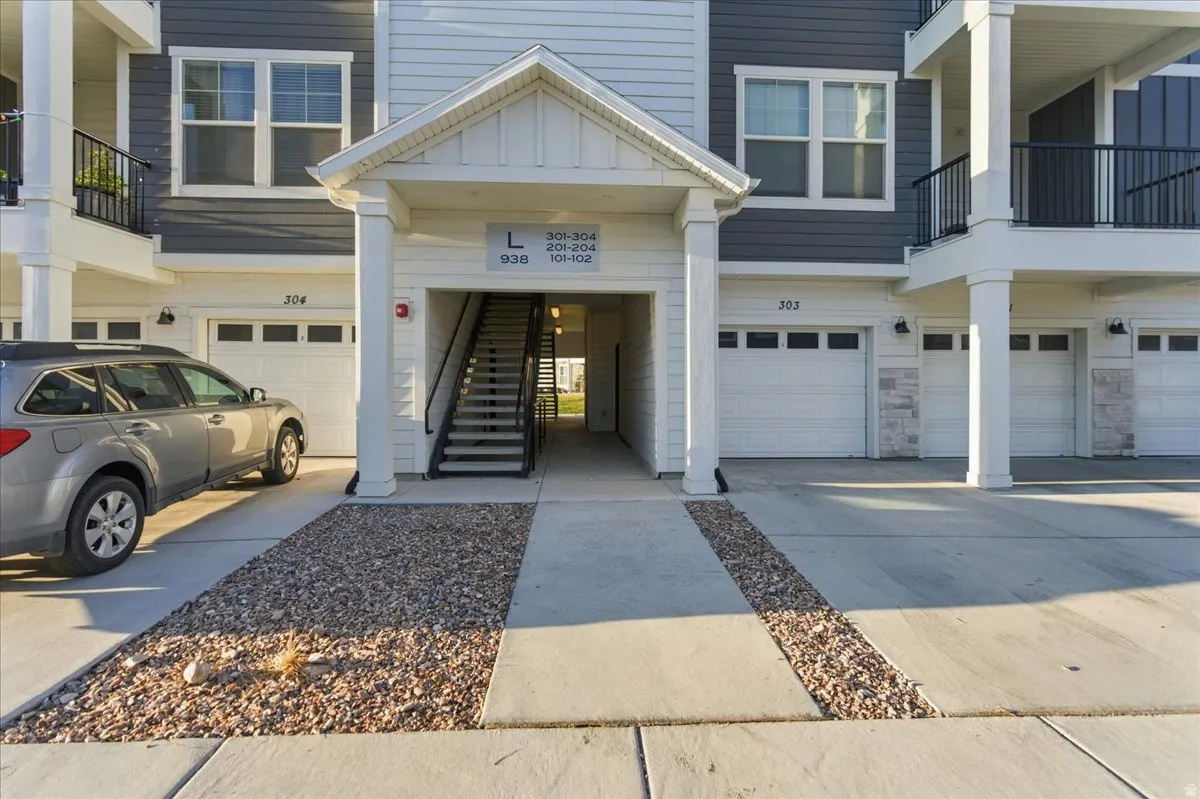 Multi-unit building entrance featuring a covered walkway and exterior staircase