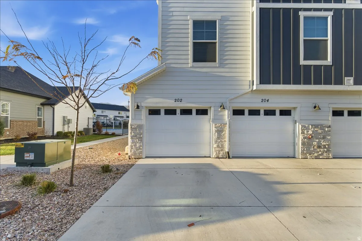 Contemporary townhome exterior featuring light siding and contrasting dark vertical siding