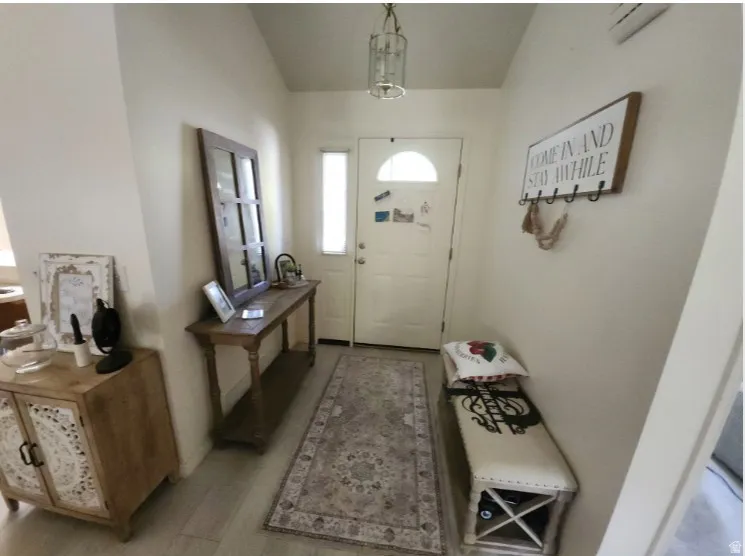 Entryway featuring a white paneled door with an arched window, a tall sidelight, and wood-finish flooring