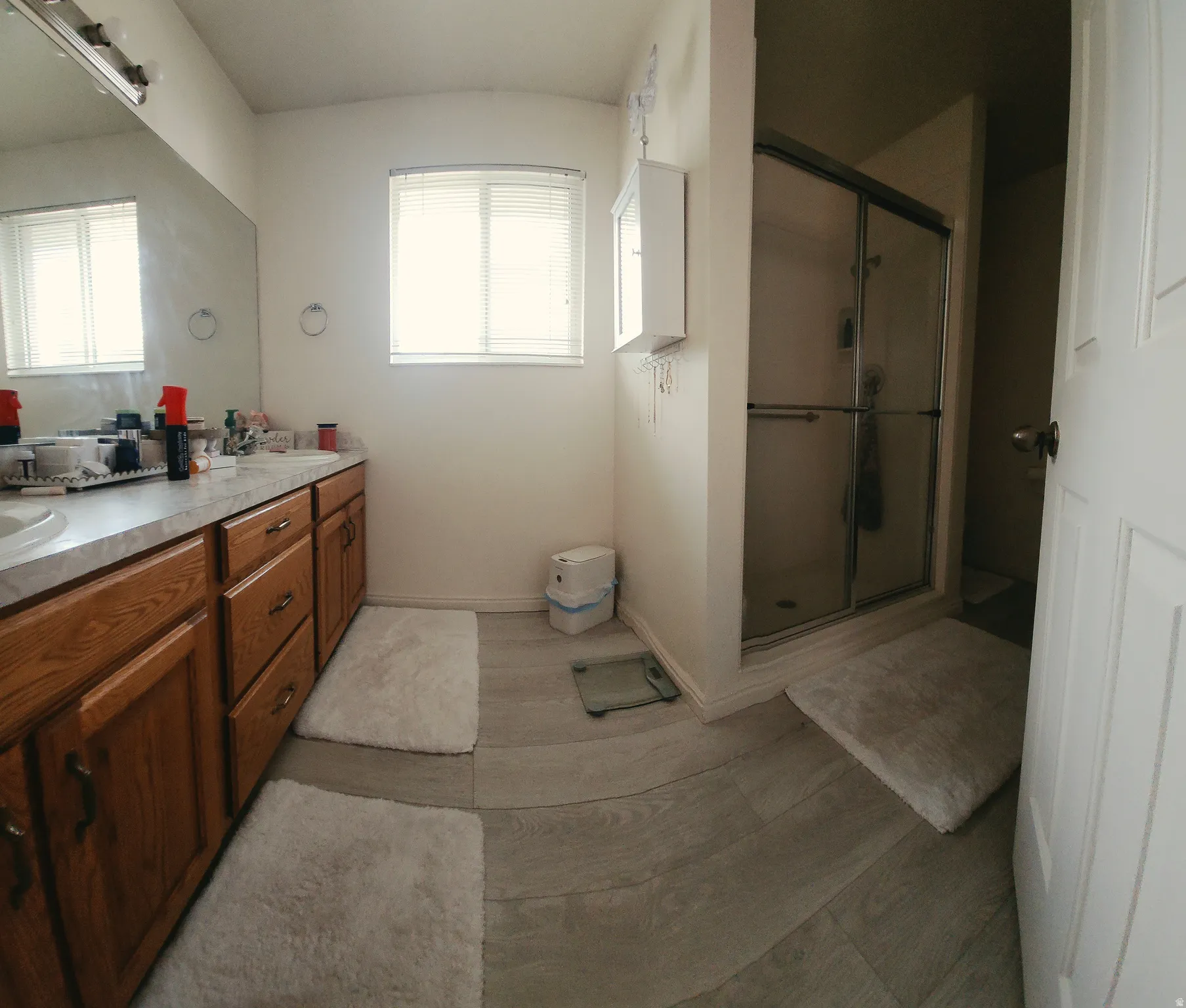 On Suite Primary Bathroom, with dual vanity with wood-finish cabinetry and light-toned countertops