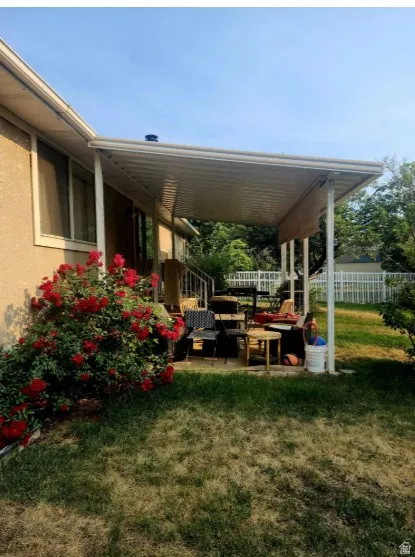 covered Patio area featuring a covered extension, concrete patio surface, and a rose bush