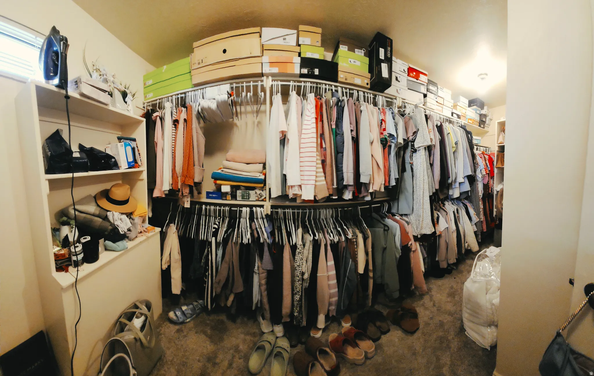 Primary Bedroom walk in closet, is spacious walk-in closet featuring extensive built-in shelving and multiple chrome hanging rods