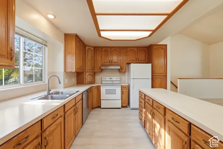 Kitchen featuring oak cabinetry, solid-surface countertops, tile flooring, and integrated recessed lighting