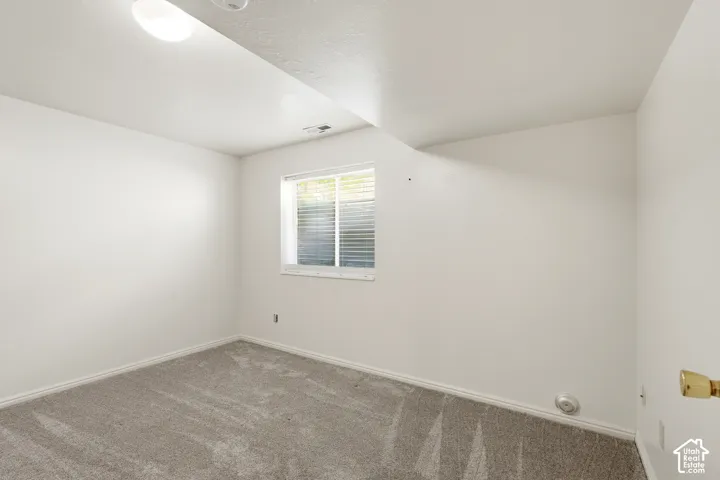 5th very large bedroom with walk in closet/ Interior room featuring neutral wall paint, carpeted flooring, and a single-pane window with integrated blinds