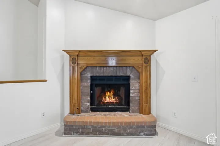 Fireplace featuring a decorative wood mantel, brick surround, and a raised brick hearth