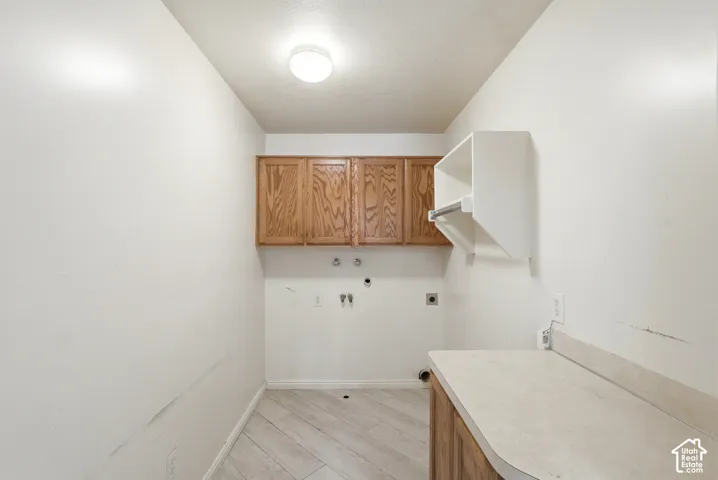 Utility area featuring wood-finish wall cabinetry, a built-in white hanging rack, laminate countertop, and wood-finish flooring
