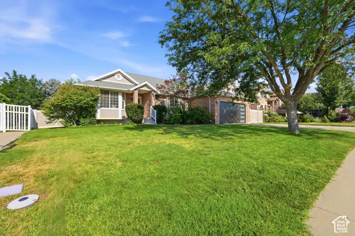 Single-story brick and siding exterior featuring a multi-gable roofline, attached multi-car garage, and established landscaping