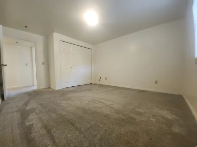 5th Bedroom , neutral wall color with a light grey carpet flooring