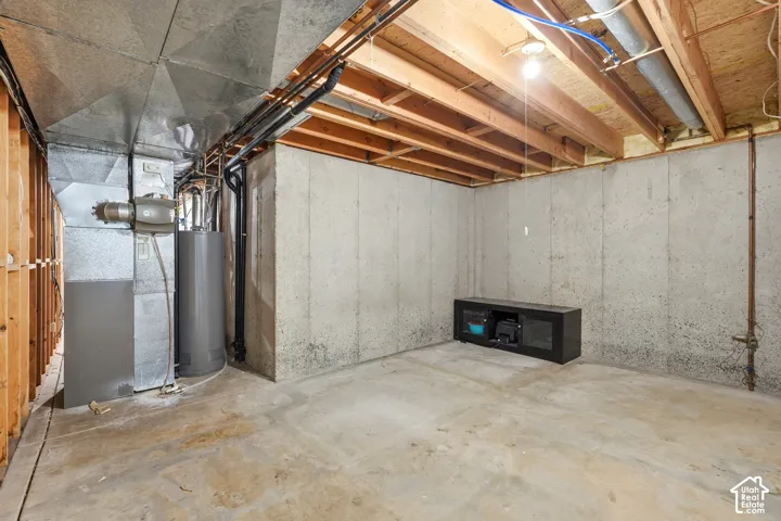 Unfinished utility area featuring exposed wood ceiling joists, poured concrete foundation walls, and metal HVAC ductwork
