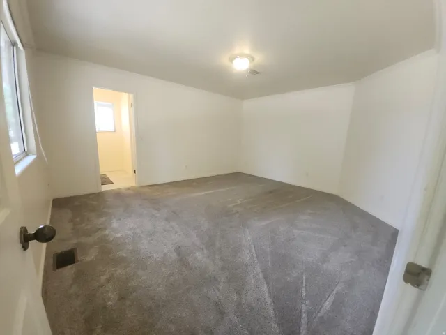 Primary bedroom with on suite bath and huge walk in closet and large shower. Spacious room featuring polished concrete flooring, fresh white walls, and recessed ceiling lighting