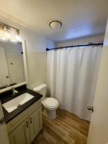 Second Bathroom featuring a light-toned vanity with dark granite countertop, undermount sink, and brushed nickel faucet