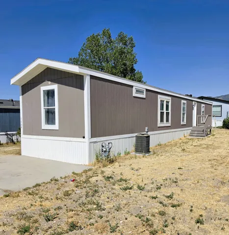 Single-level residence featuring a gray siding exterior, white trim, and a white perimeter skirting
