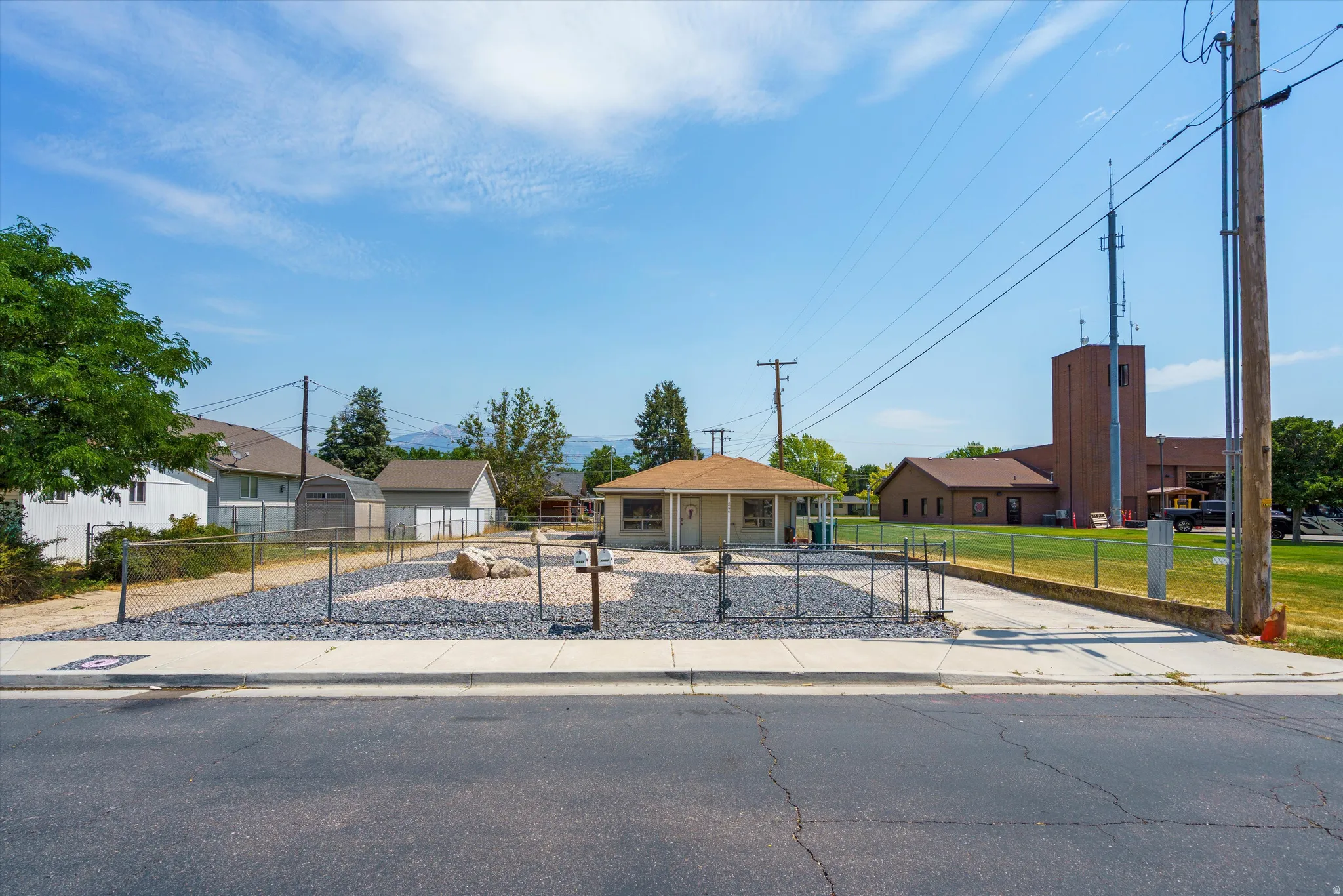 Single-story property with a low-pitch roof and a chain-link fenced yard
