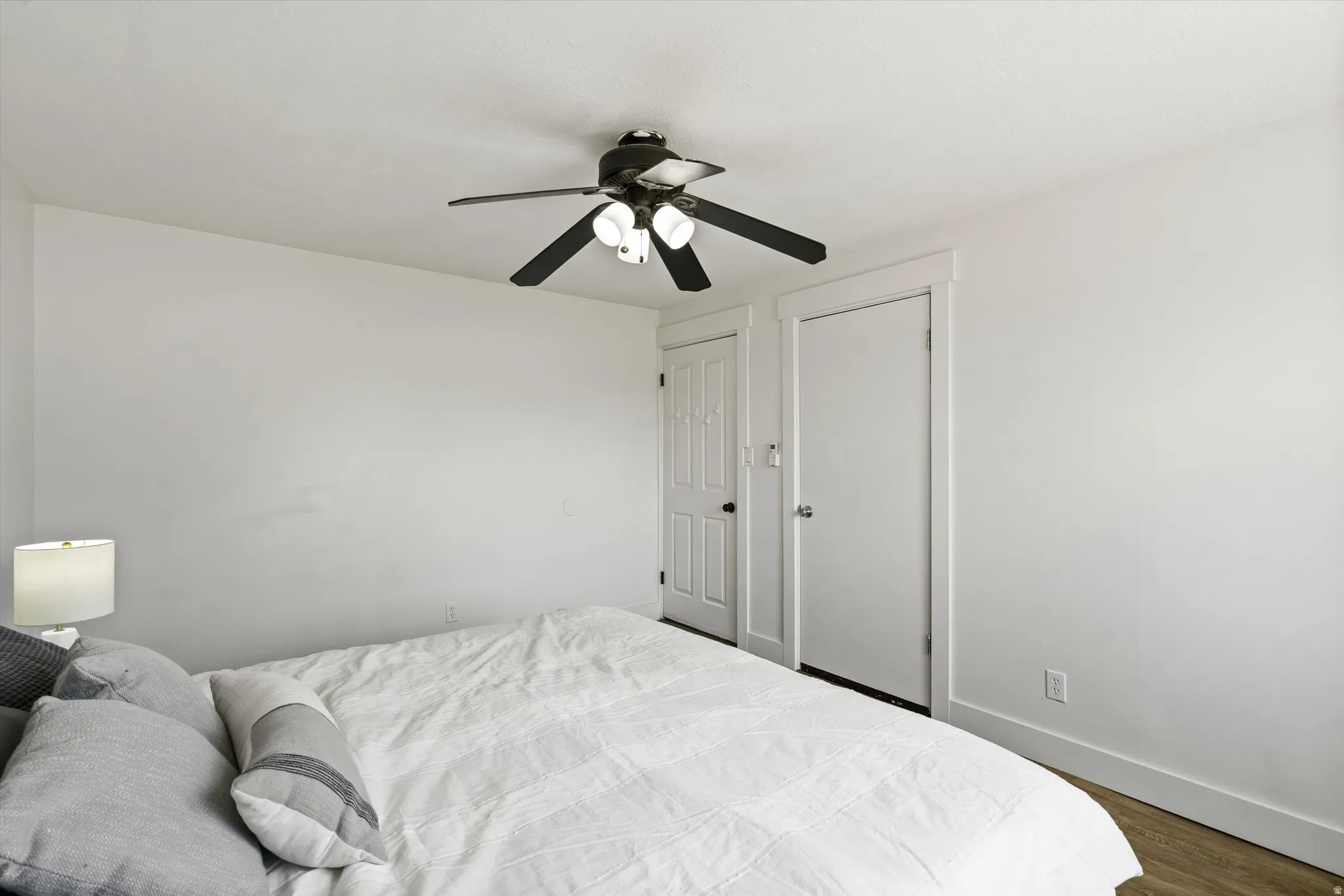 Bedroom featuring white walls and wood-finish flooring