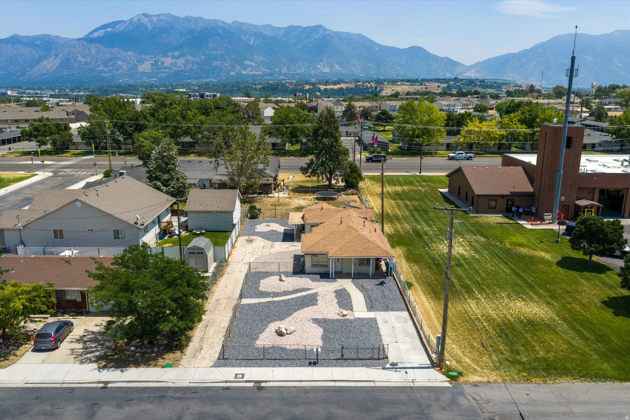 Ranch-style residence featuring a prominent pitched roof and a rock-landscaped front yard with a decorative path