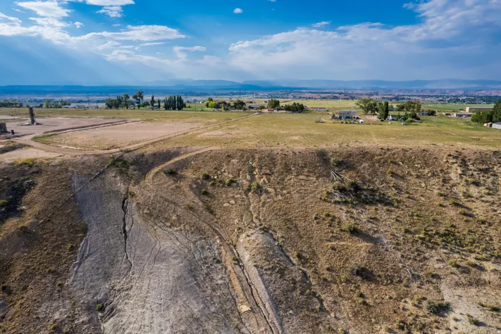 Expansive land parcel with visible elevation changes and distant rural properties