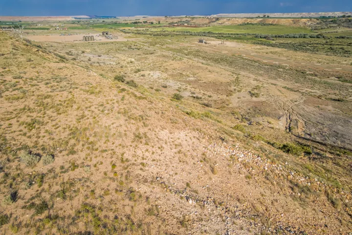 Expansive land parcel featuring varied topography, including a gentle slope and flatter areas