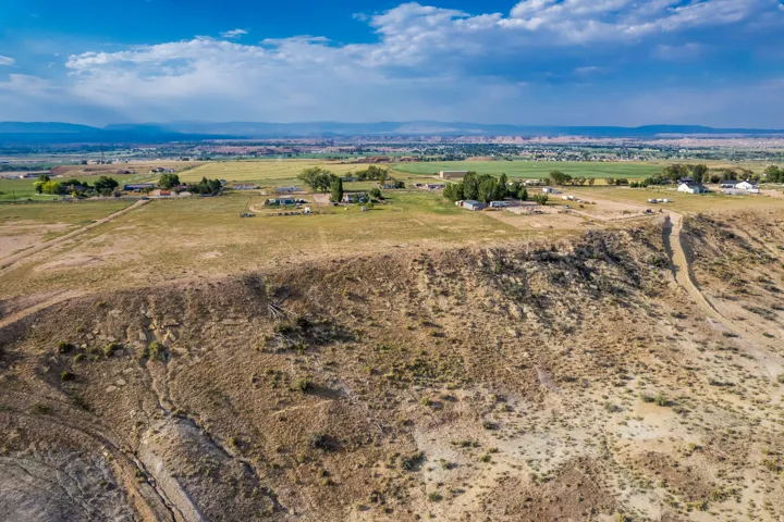 Expansive rural property featuring a vast elevated land area and distant developed agricultural fields