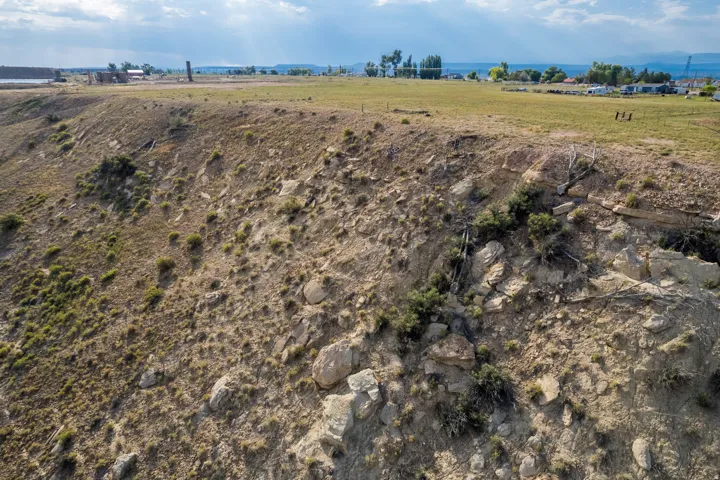 Expansive undeveloped land featuring a varied terrain, including a grassy plateau and a rocky embankment