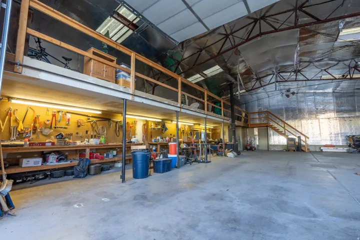 Spacious commercial-style interior with a high, vaulted ceiling and exposed industrial-style trusses
