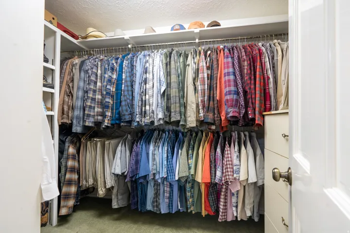 Custom closet system featuring dual-tier hanging rods, integrated shelving, and built-in drawer storage
