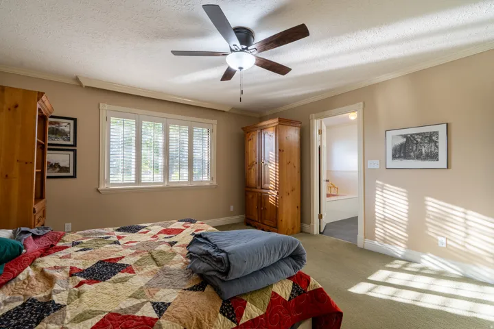 Spacious room featuring neutral painted walls, light-colored carpeting, and a ceiling fan with integrated lighting