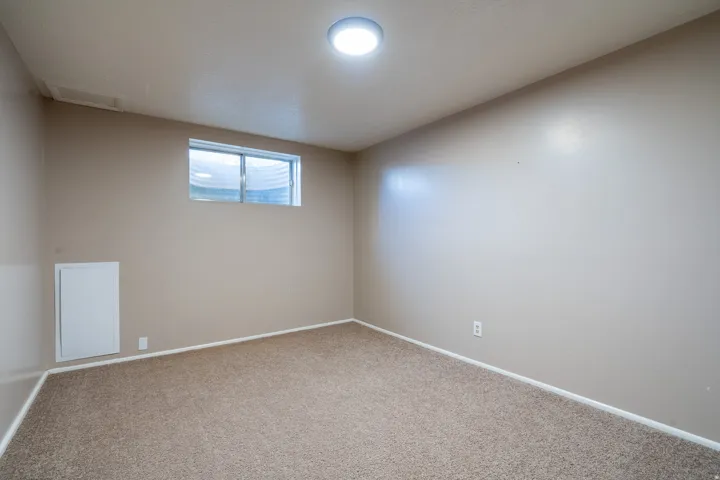 Carpeted room with a recessed window, neutral wall paint, and a flush-mount ceiling light fixture
