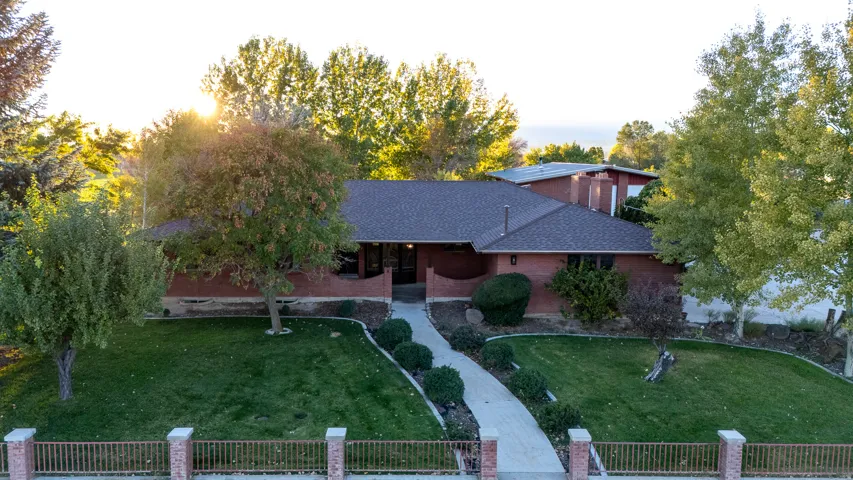 Brick exterior home with a dark shingle roof