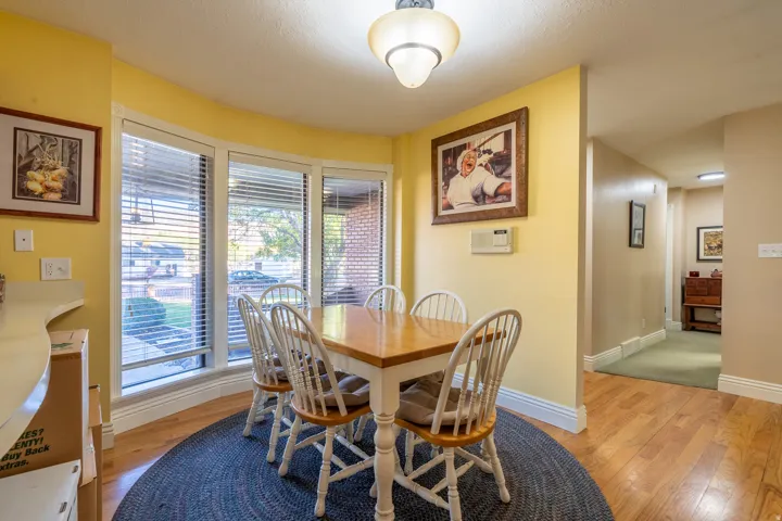 Dining area with a curved bay window featuring horizontal blinds