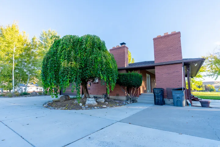 Red brick exterior featuring two prominent chimneys with decorative caps