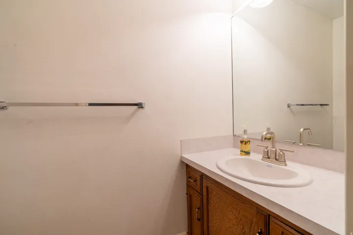 Bathroom vanity featuring a built-in sink, brushed nickel faucet, and a large wall-mounted mirror