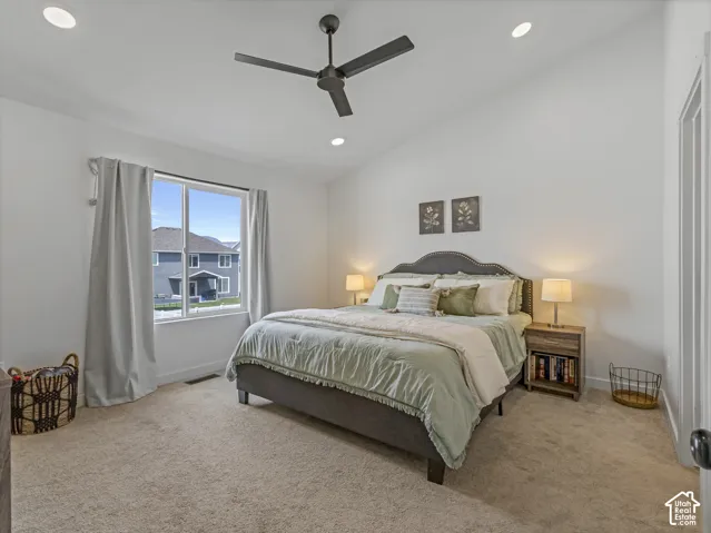 Spacious bedroom featuring vaulted ceilings, recessed lighting, a ceiling fan, and plush carpeting