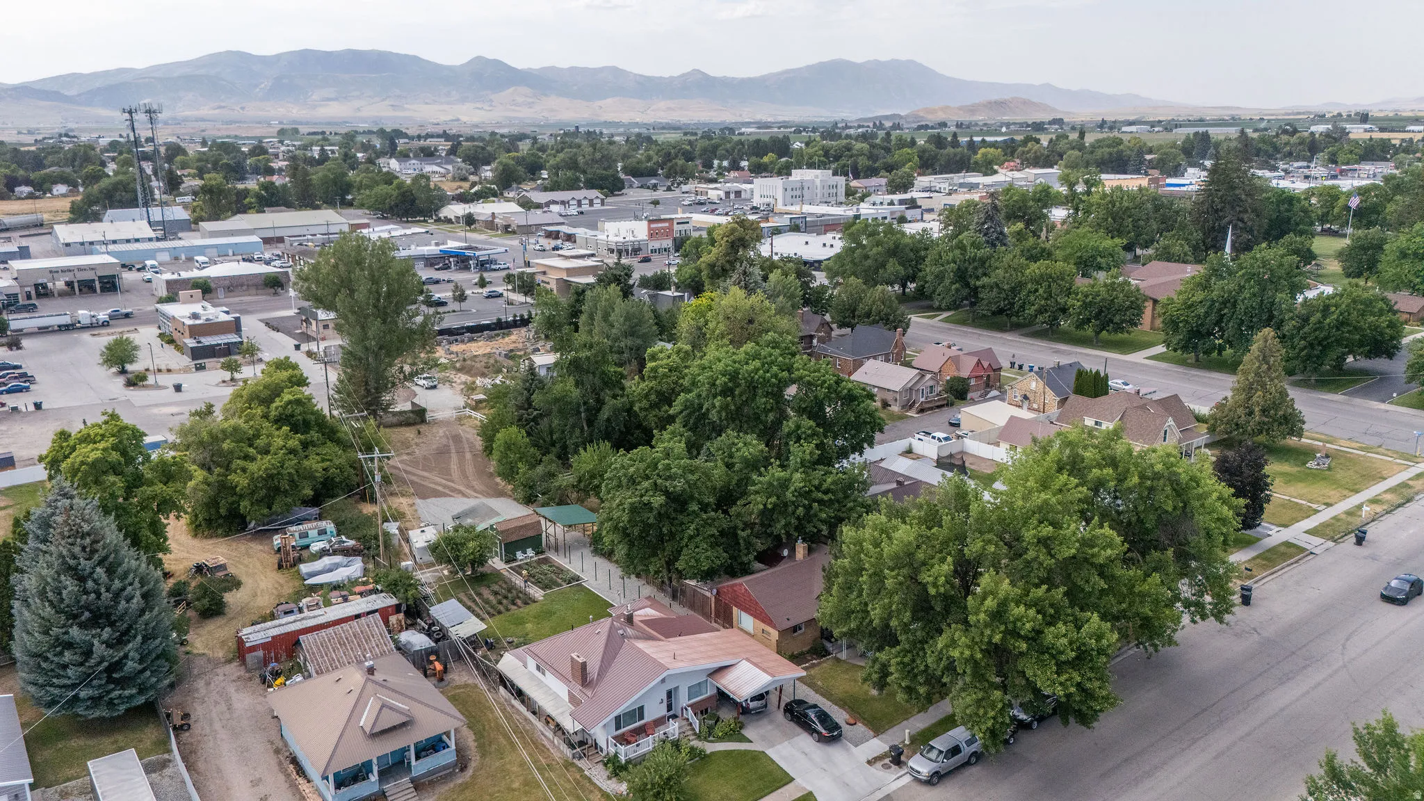 Aerial perspective showcasing residential properties and commercial establishments framed by distant mountains