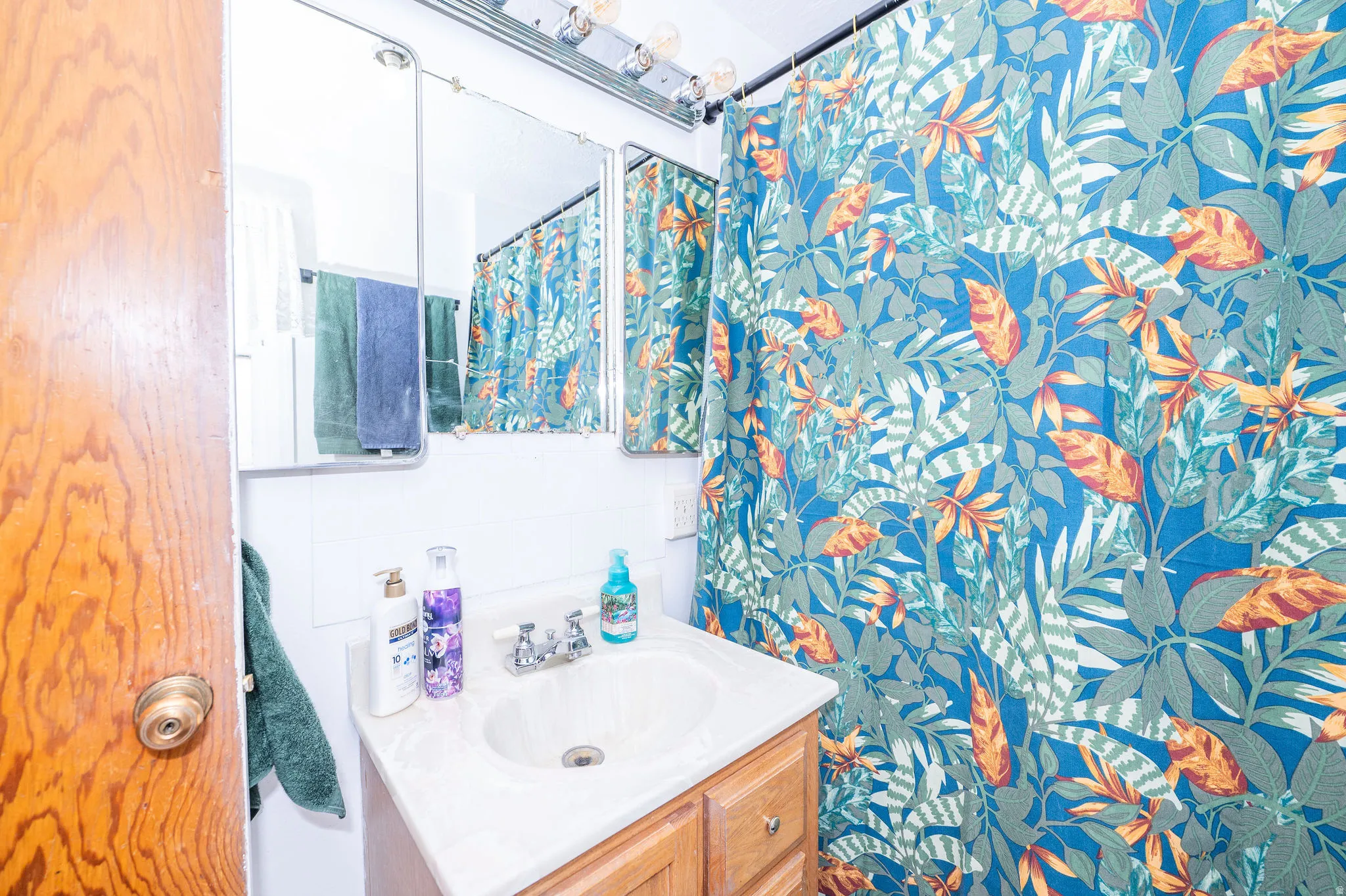 Bathroom featuring a wood-finish vanity with an integrated sink, a wall-mounted medicine cabinet, and overhead lighting