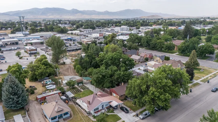 Aerial perspective showcasing residential properties and commercial establishments framed by distant mountains