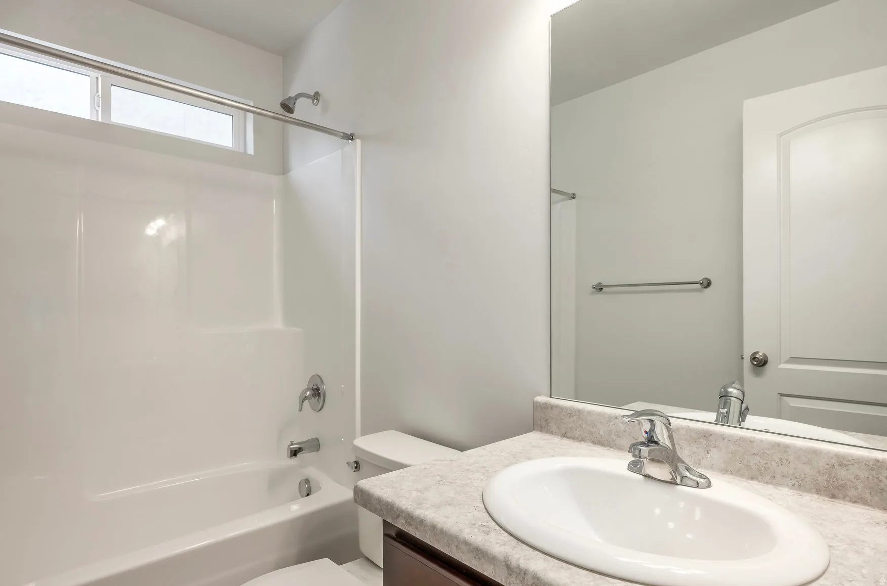 Bathroom featuring a white tub-shower combination, a vanity with an oval undermount sink, a chrome faucet, and a large wall-mounted mirror