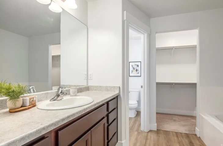 Bathroom featuring a vanity with dark wood-finish cabinetry, a light-toned countertop, and an oval undermount sink