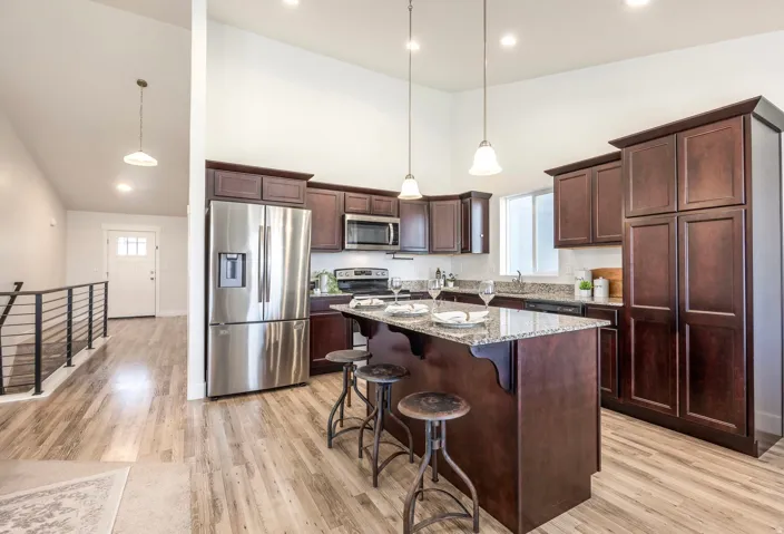 Kitchen featuring dark wood cabinetry, stainless steel appliances, and a central island with granite countertops