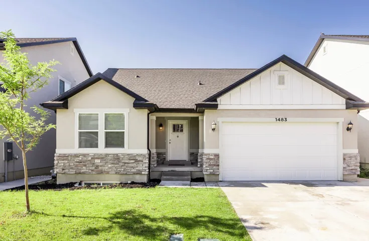 Contemporary single-story residence featuring a two-car garage, stone veneer accents, and a covered entryway